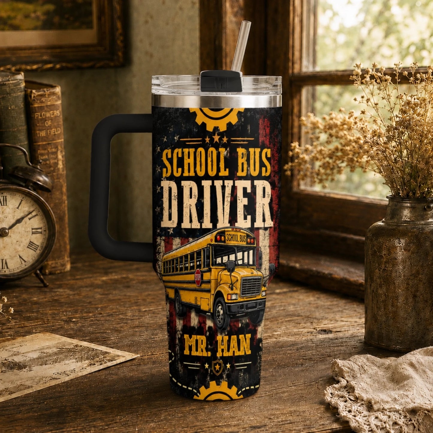 A handled tumbler with a straw, featuring a yellow school bus design and 'School Bus Driver' text, sits on a rustic wooden table.