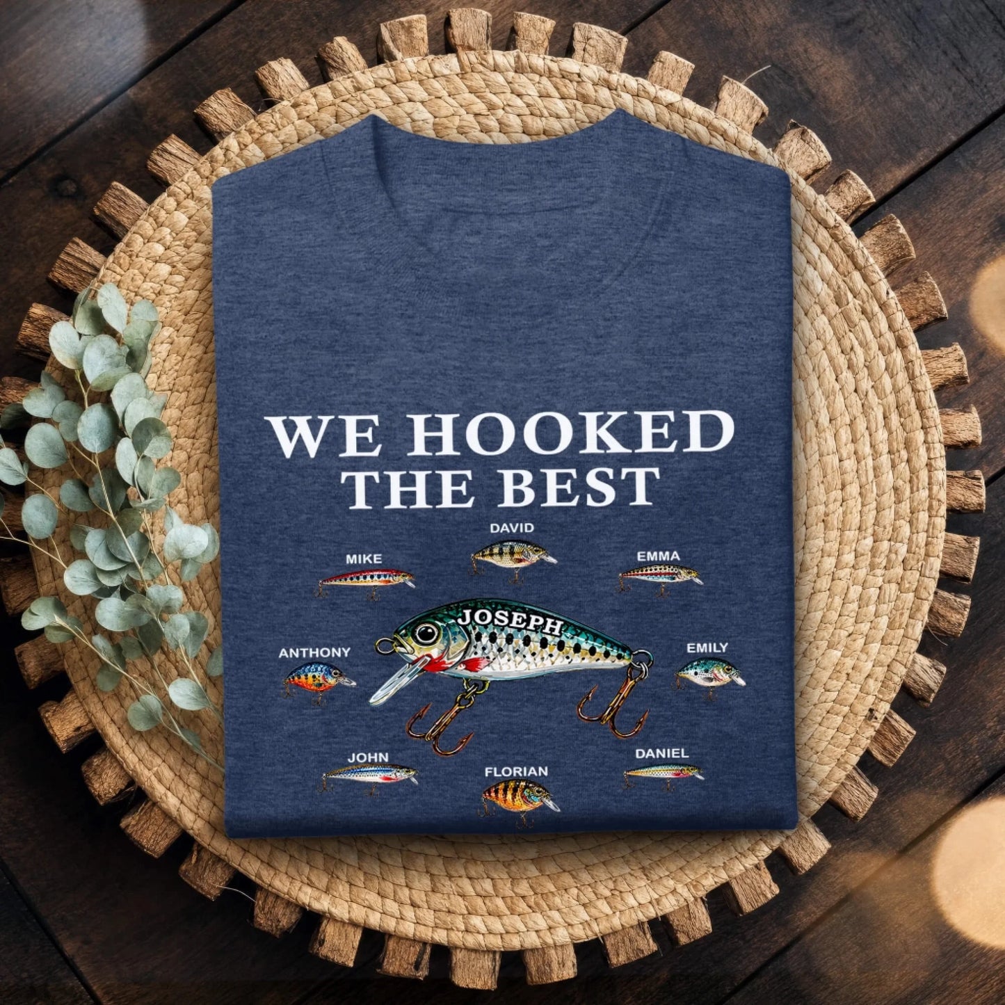 Blue t-shirt with fishing lure design and text on a woven mat