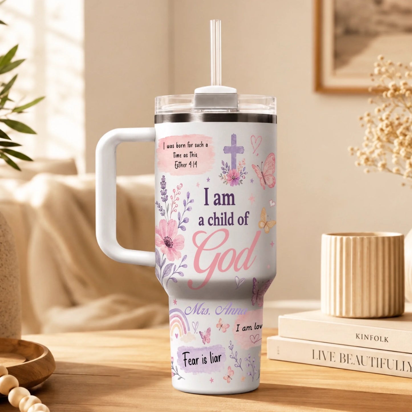 White personalized tumbler with 'I am a child of God' text, floral motifs, and a cross, set in a cozy home environment.