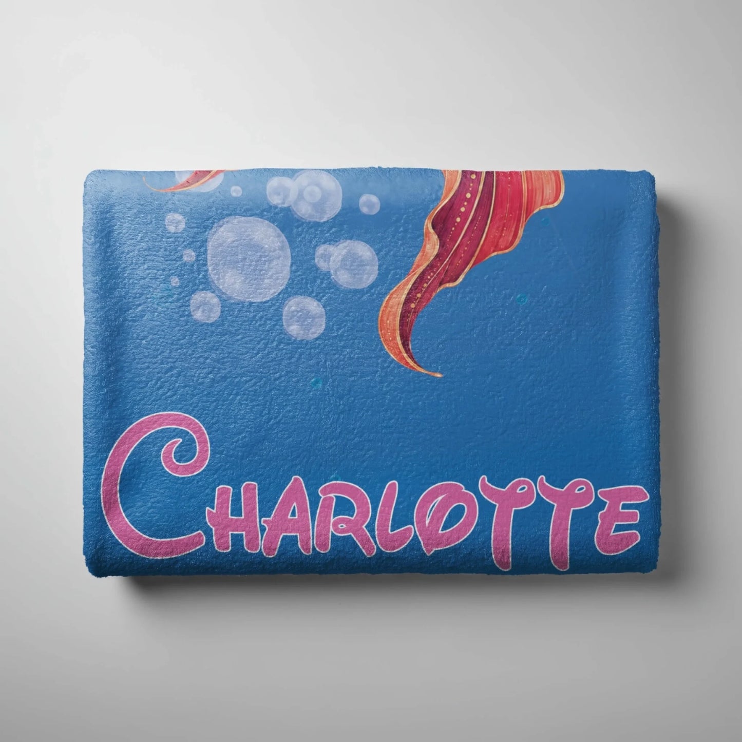Custom blue mermaid beach towel featuring a colorful mermaid tail and the personalized name Charlotte.