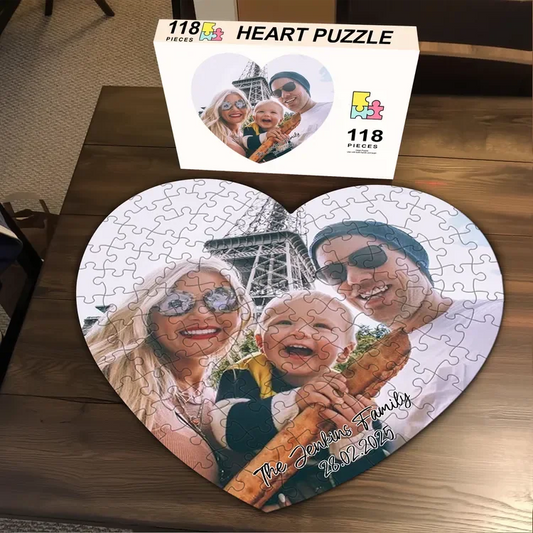 Heart-shaped puzzle with family photos on a wooden surface, accompanied by the packaging box.