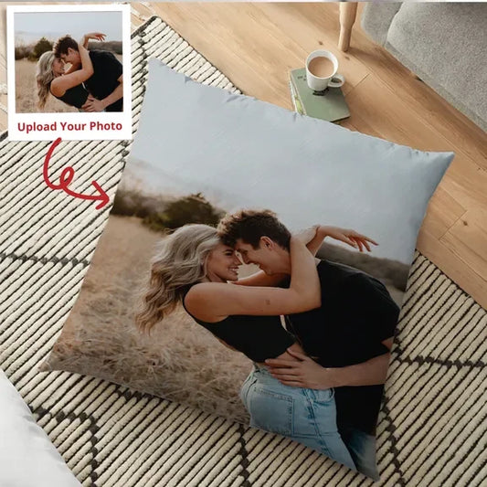 Personalized pillow with a photo of a couple embracing on a wooden floor.
