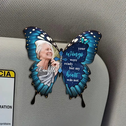 Butterfly-shaped memorial with a photo of a woman and text on a car's headrest.