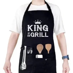 Person wearing a black apron with 'King of the Grill' text and grill tools.