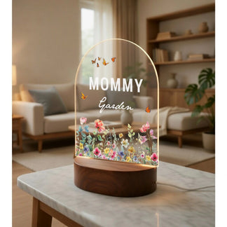 Decorative lamp with 'Mommy Garden' text on a marble table in a living room.
