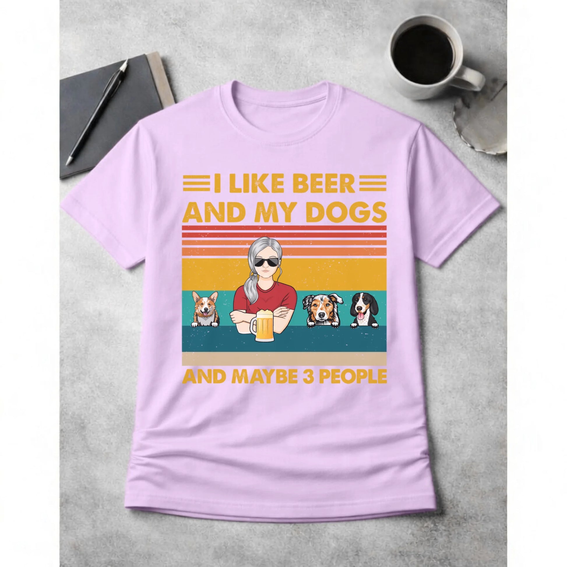 Purple t-shirt with a graphic of a woman with dogs and text on a gray surface with a cup and book.