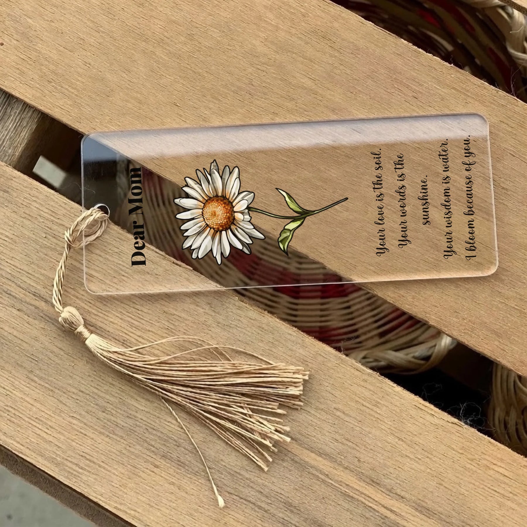 Bookmark with daisy illustration and text on a wooden surface
