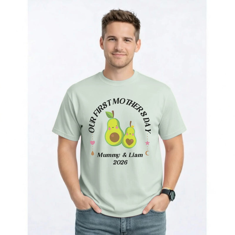 Man wearing a light green t-shirt with a graphic and text for First Mother's Day, standing against a white background.