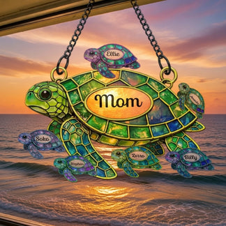 Decorative turtle ornament with 'Mom' on a sunset beach background