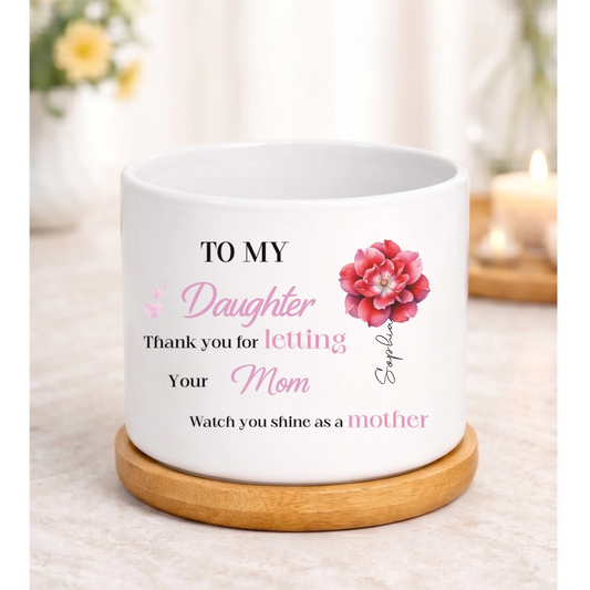 White ceramic plant pot on a wooden saucer featuring a sentimental mother-to-daughter message in black and pink text, with a pink flower illustration and the name Sophia printed vertically.