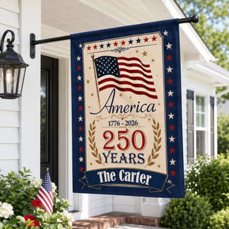 Decorative flag celebrating America's 250th anniversary on a house exterior.