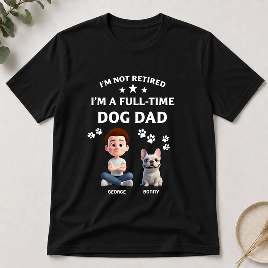 Black t-shirt with a graphic of a man and dog, text 'I'm not retired, I'm a full-time dog dad', on a light background.