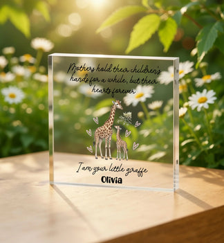 Clear glass block with giraffe illustration and text on a wooden surface with a natural background