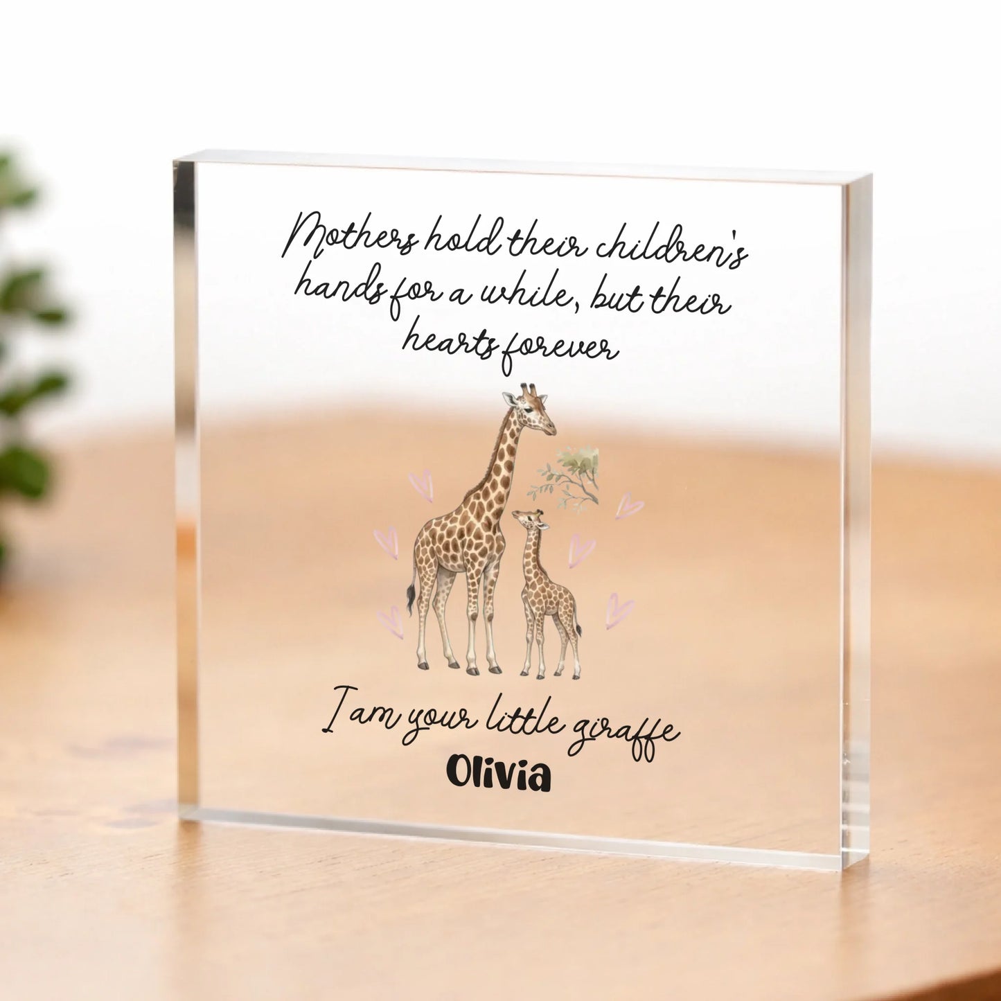 Acrylic block with giraffe illustration and text on a wooden surface