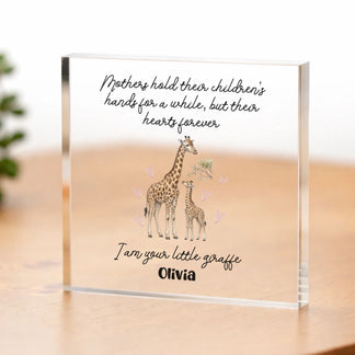 Acrylic block with giraffe illustration and text on a wooden surface