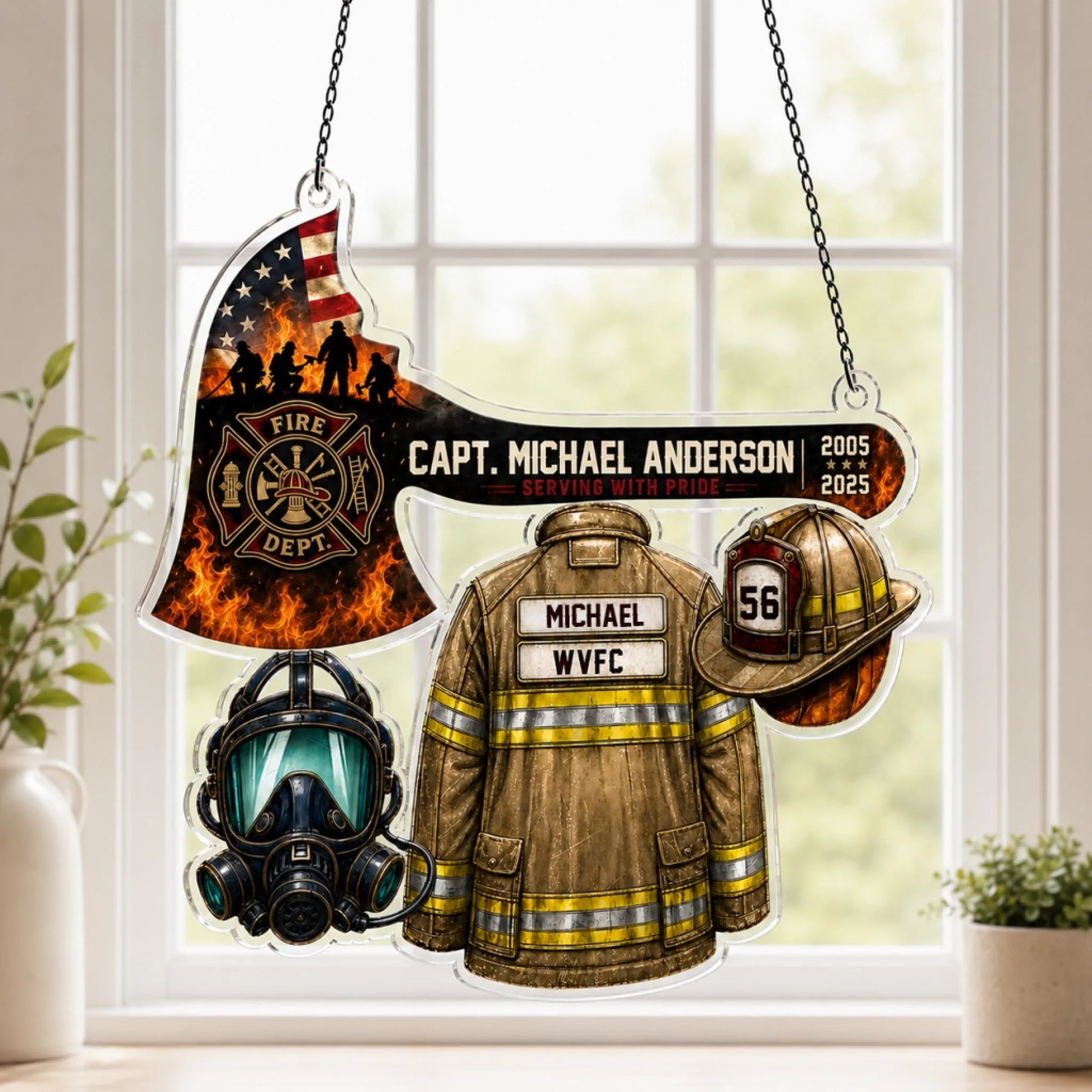 An acrylic hanging firefighter ornament shaped like an axe with an American flag, a jacket, helmet, and mask, against a window.
