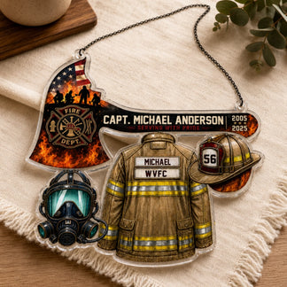 A clear acrylic hanging plaque in the shape of firefighter gear, including an axe, jacket, helmet, and mask, displayed on a cream fabric.