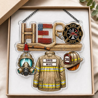 An acrylic ornament featuring firefighter gear and the word "HERO" in a gift box with white foam padding.