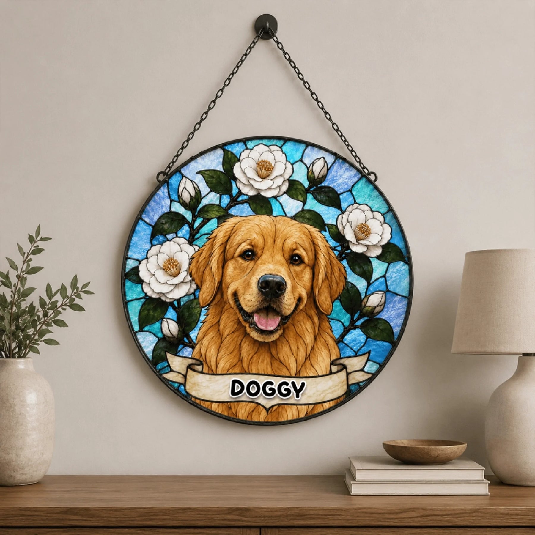 A circular stained-glass style ornament featuring a golden retriever and flowers, with a 'DOGGY' banner, displayed indoors above a wooden table.