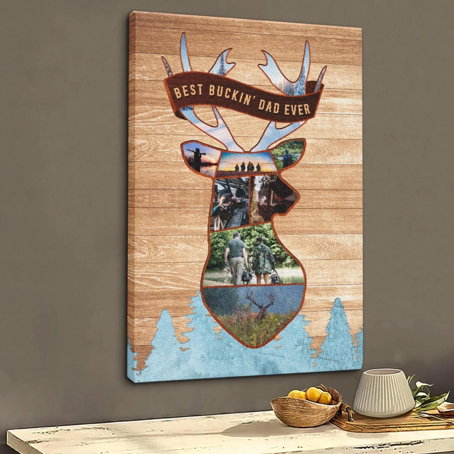A vertical canvas print with a deer head collage of hunting photos and "BEST BUCKIN' DAD EVER" text, displayed on a table.