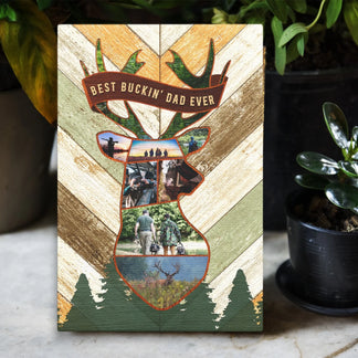 A vertical canvas print featuring a deer head collage of hunting photos and "BEST BUCKIN' DAD EVER" text, surrounded by plants.