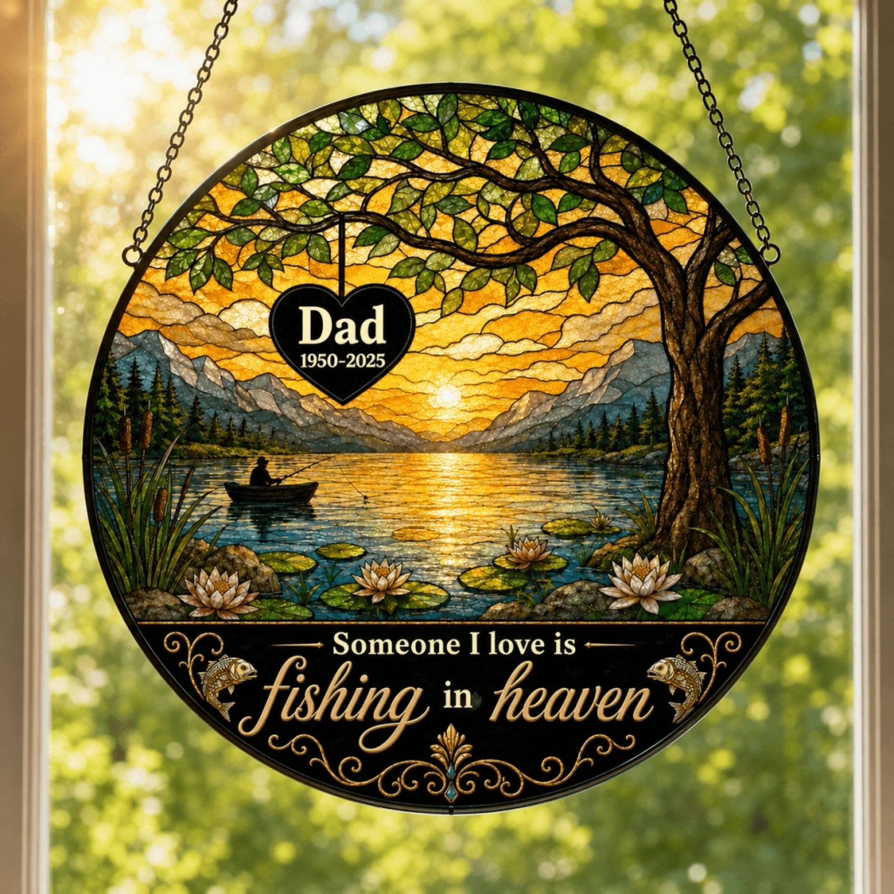 Round stained glass-style panel showing a sunset lake scene with a person fishing, mountains, trees, and water lilies. Text reads: "Dad 1950-2025" and "Someone I love is fishing in heaven."