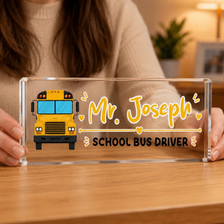 A person holds a clear rectangular acrylic block with a yellow school bus illustration and "Mr. Joseph School Bus Driver" text.