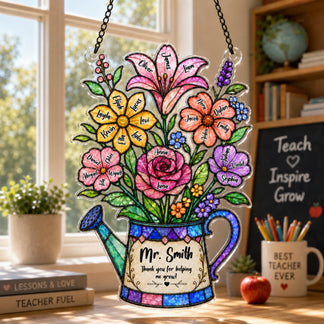 A colorful watering can shaped plaque with named flowers and a thank you message, hanging in a classroom setting in front of a bright window.