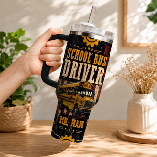 A hand holds a handled tumbler with a straw, displaying a yellow school bus design and 'School Bus Driver' text, including 'MR. HAN'.