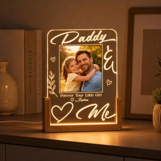 Decorative light sign with a photo of a man and a child, text 'Daddy & Me', and books in the background.