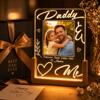 Personalized photo frame with a father and daughter photo, gift box, and card on a wooden surface.