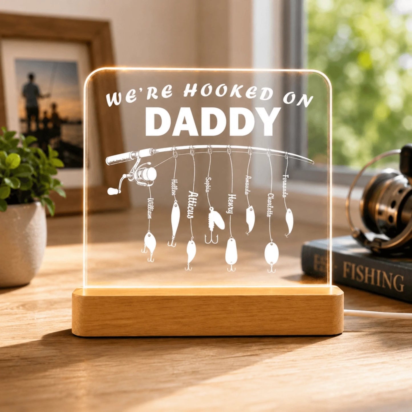 Decorative plaque with fishing theme and 'We're Hooked on Daddy' text on a wooden base.