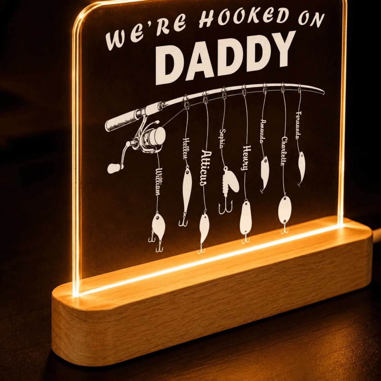 Decorative sign with fishing rod and lures, featuring 'We're Hooked on Daddy' text.