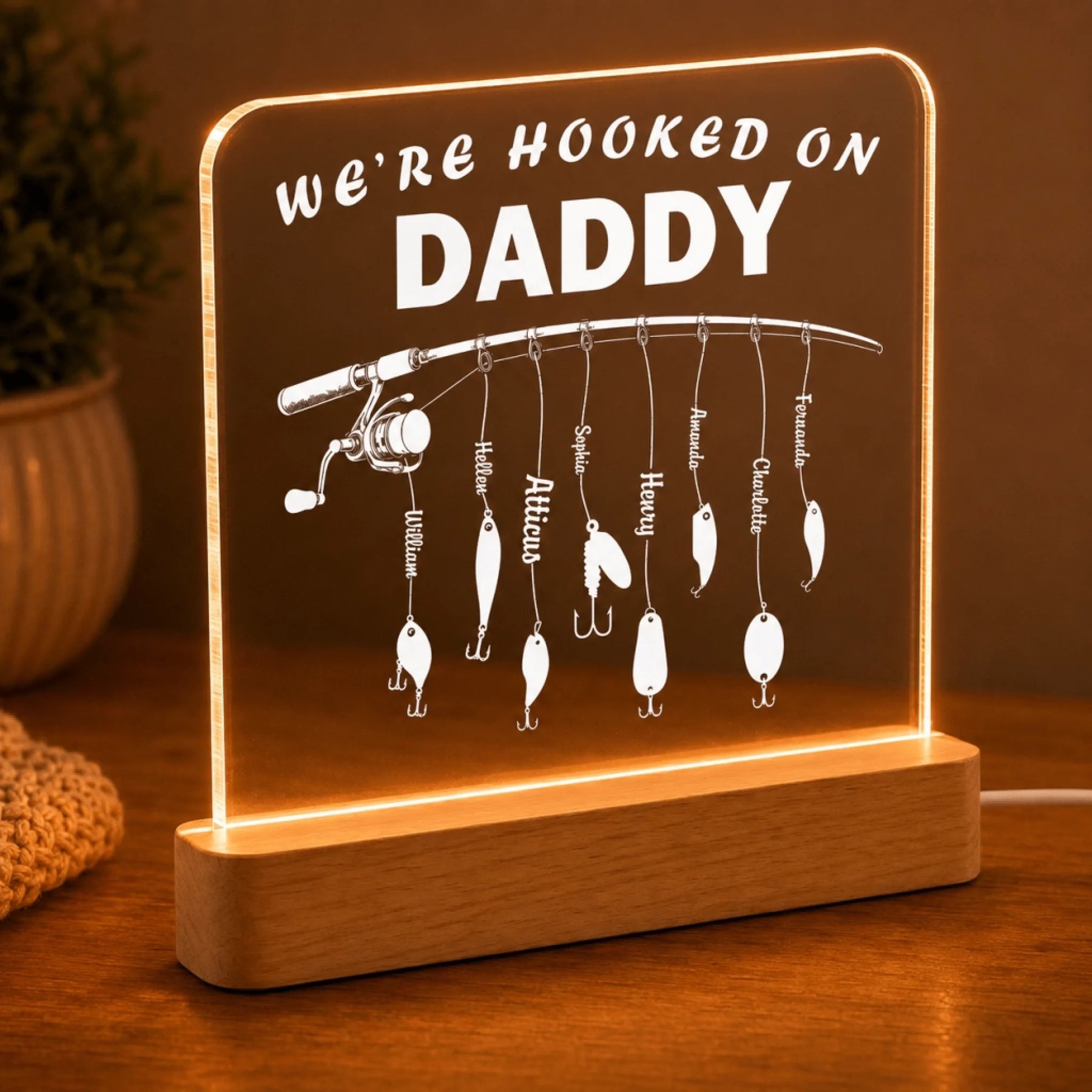 Decorative lamp with fishing theme and 'We're Hooked on Daddy' text on a wooden base.