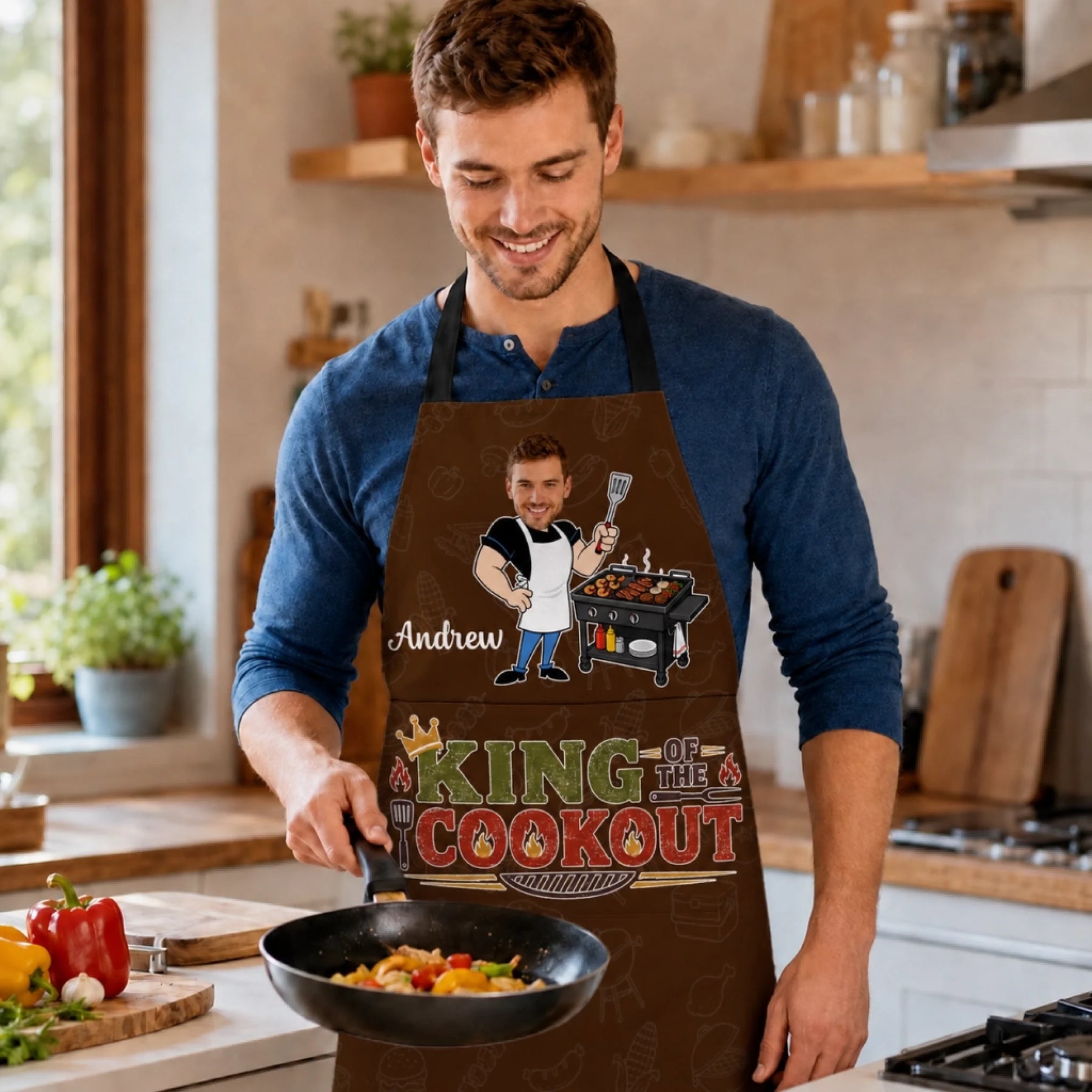 Man in a kitchen wearing a personalized apron with a graphic design.