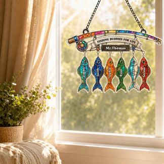 Decorative hanging sign with colorful fish and 'Fishing Buddies for Life' text, placed by a window.
