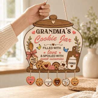 Decorative sign shaped like a cookie jar with personalized names, held by a hand.