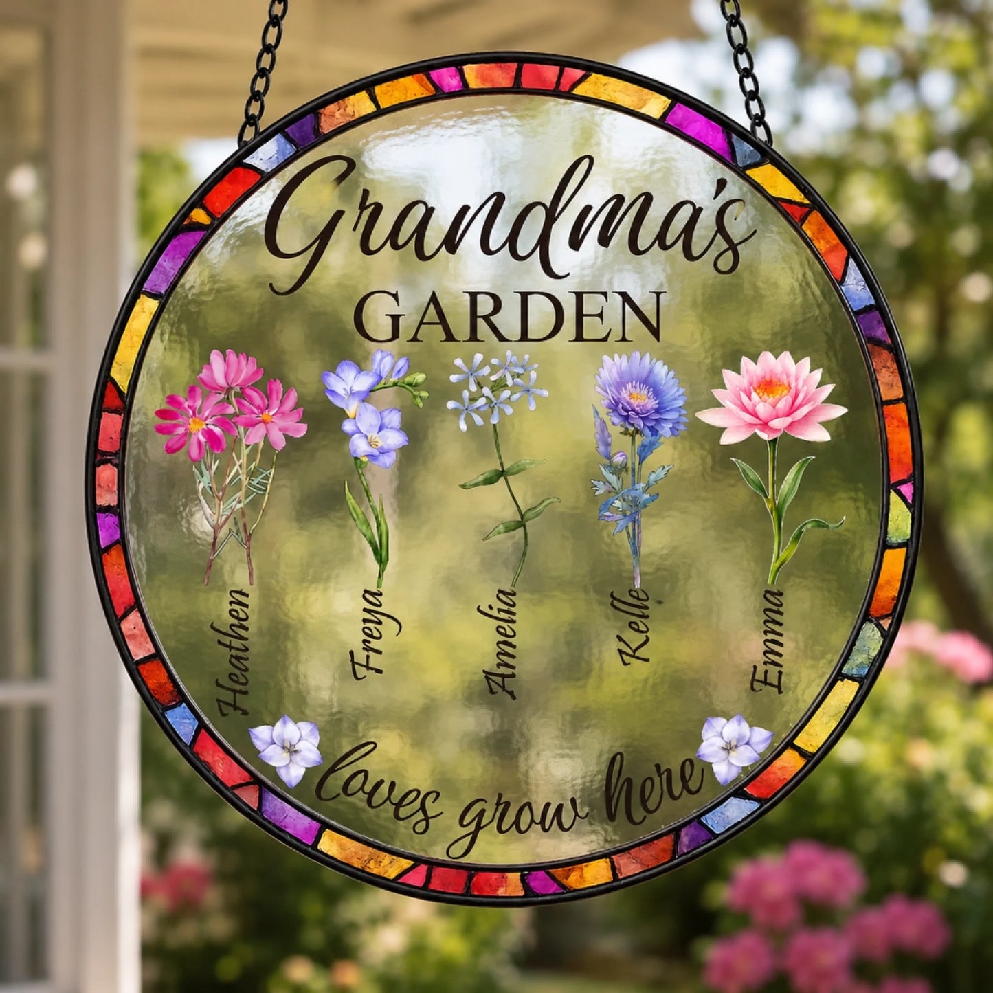 Decorative glass panel with floral designs and text 'Grandma's Garden' in a garden setting.