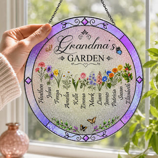 Decorative round sign with floral designs and names, held in front of a window with plants.