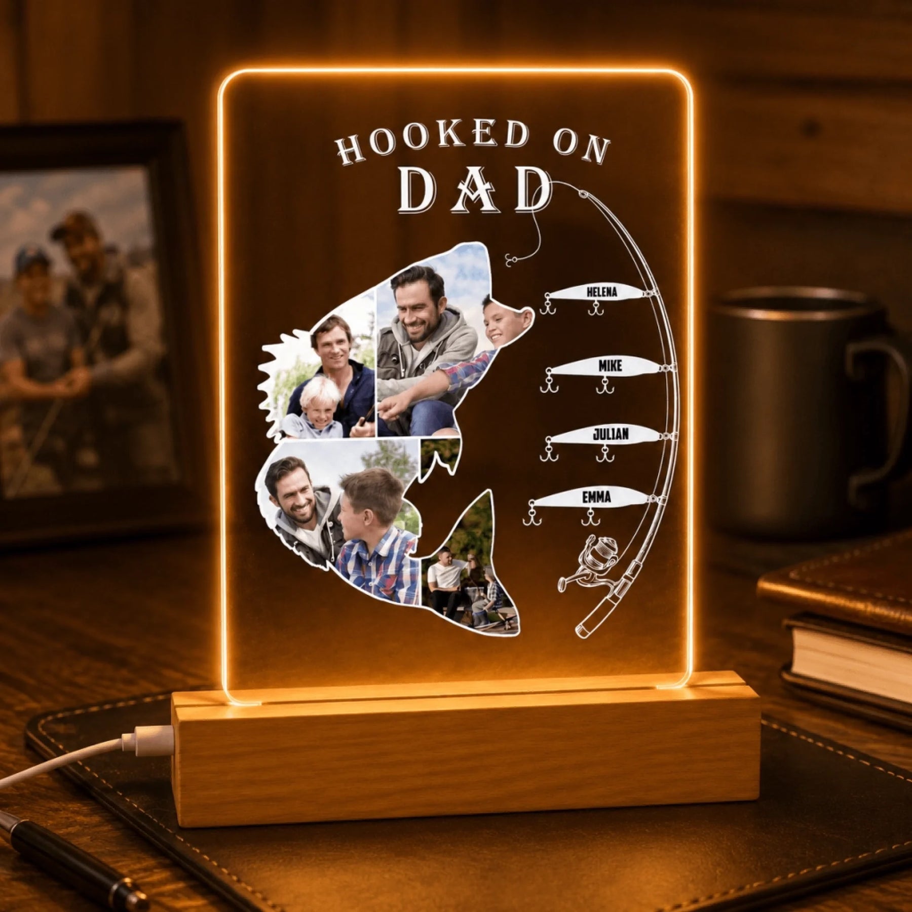 Personalized light-up sign shaped like a fish with family photos and 'Hooked on Dad' text on a wooden base.