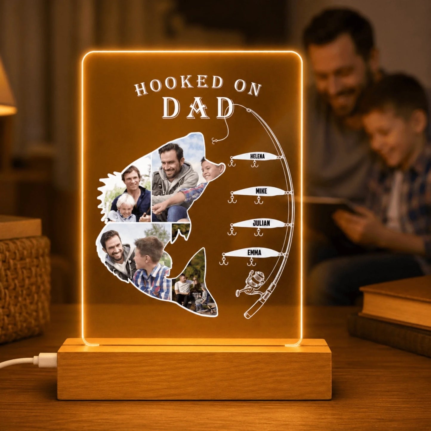 Decorative lamp with fishing theme and family photos, placed on a wooden surface.