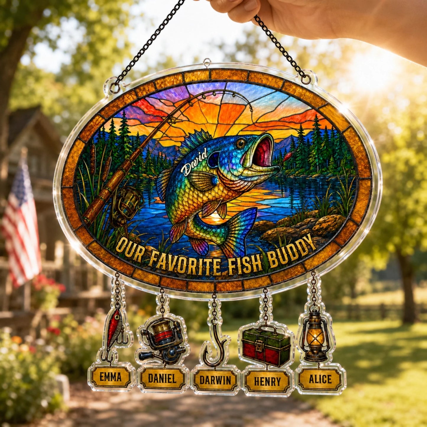 Decorative stained glass panel with fish and names, hanging outdoors.