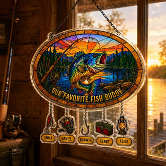 Stained glass panel with fish design and names, hanging by a window with a sunset view.
