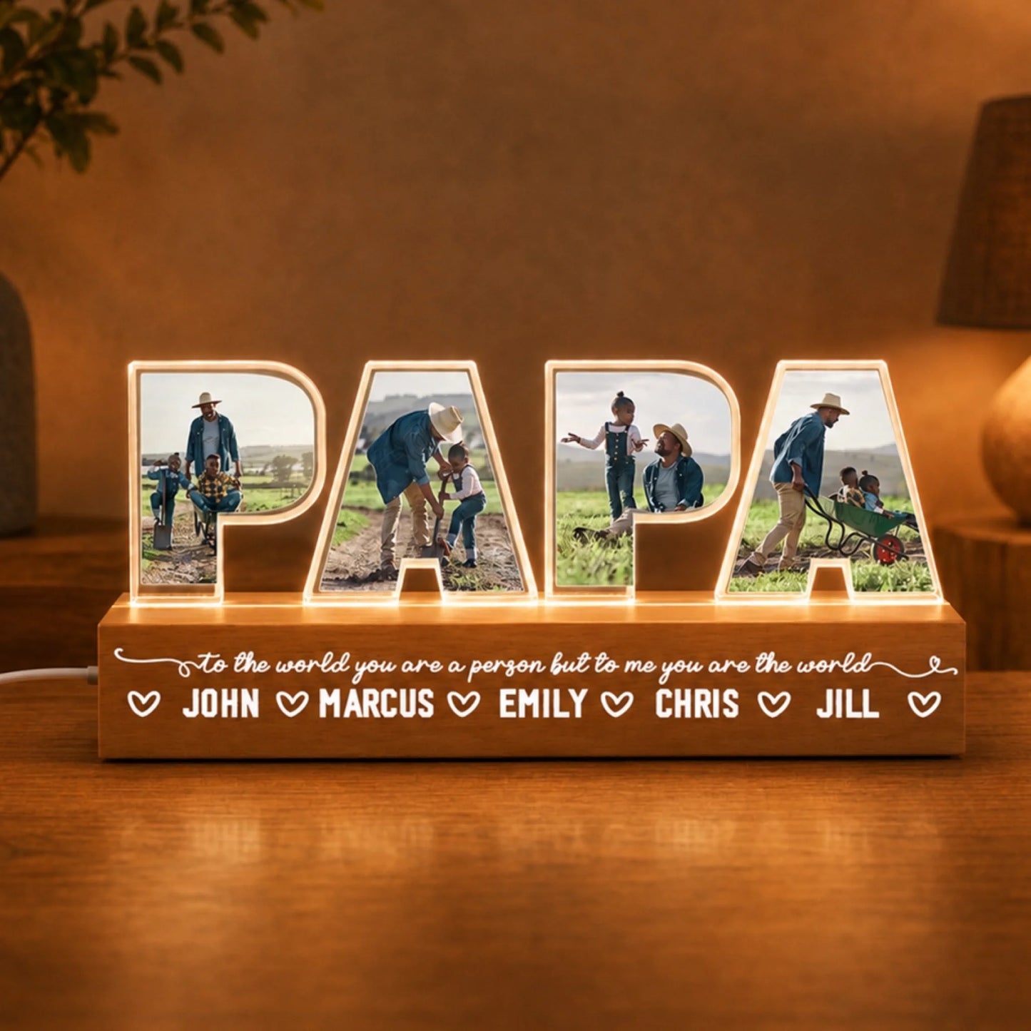 Personalized wooden lamp with family photos inside each letter, placed on a wooden surface.