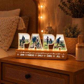 Personalized 'PAPA' lamp with photos on a wooden surface in a cozy room.