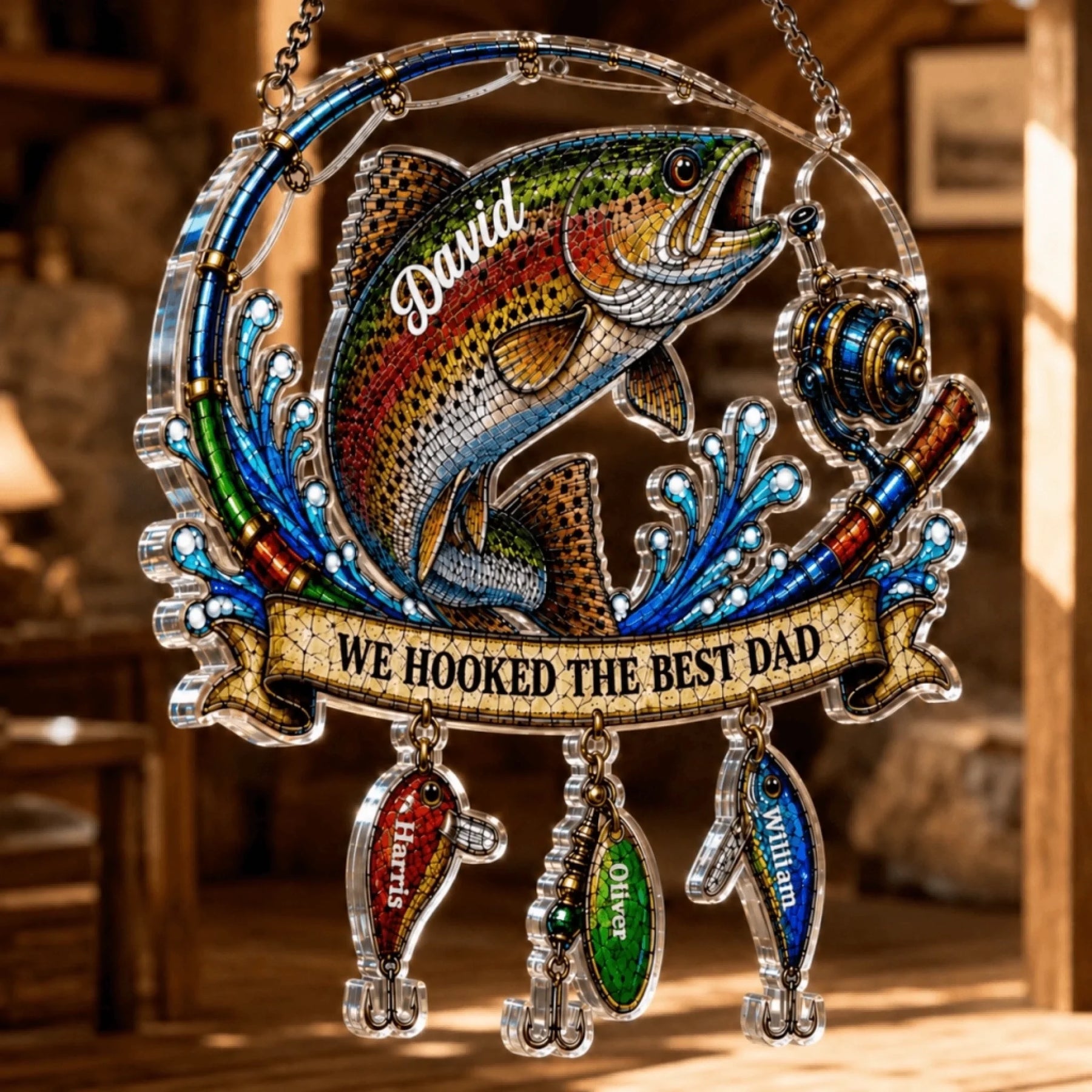 Decorative fishing ornament with a fish and 'We Hooked the Best Dad' text, hanging indoors.