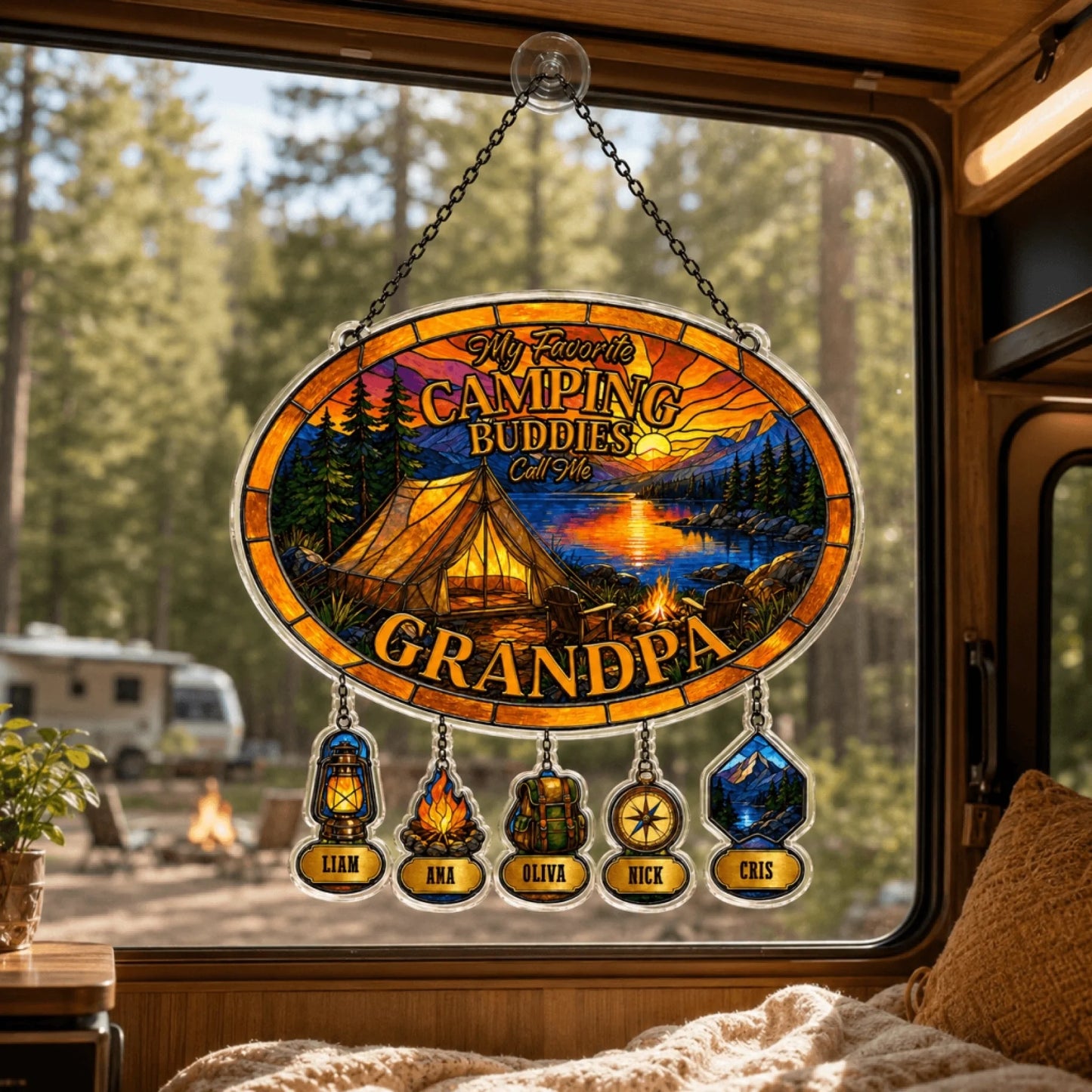 Decorative sign with camping theme hanging inside a vehicle, showing a scenic view of a lake and trees.