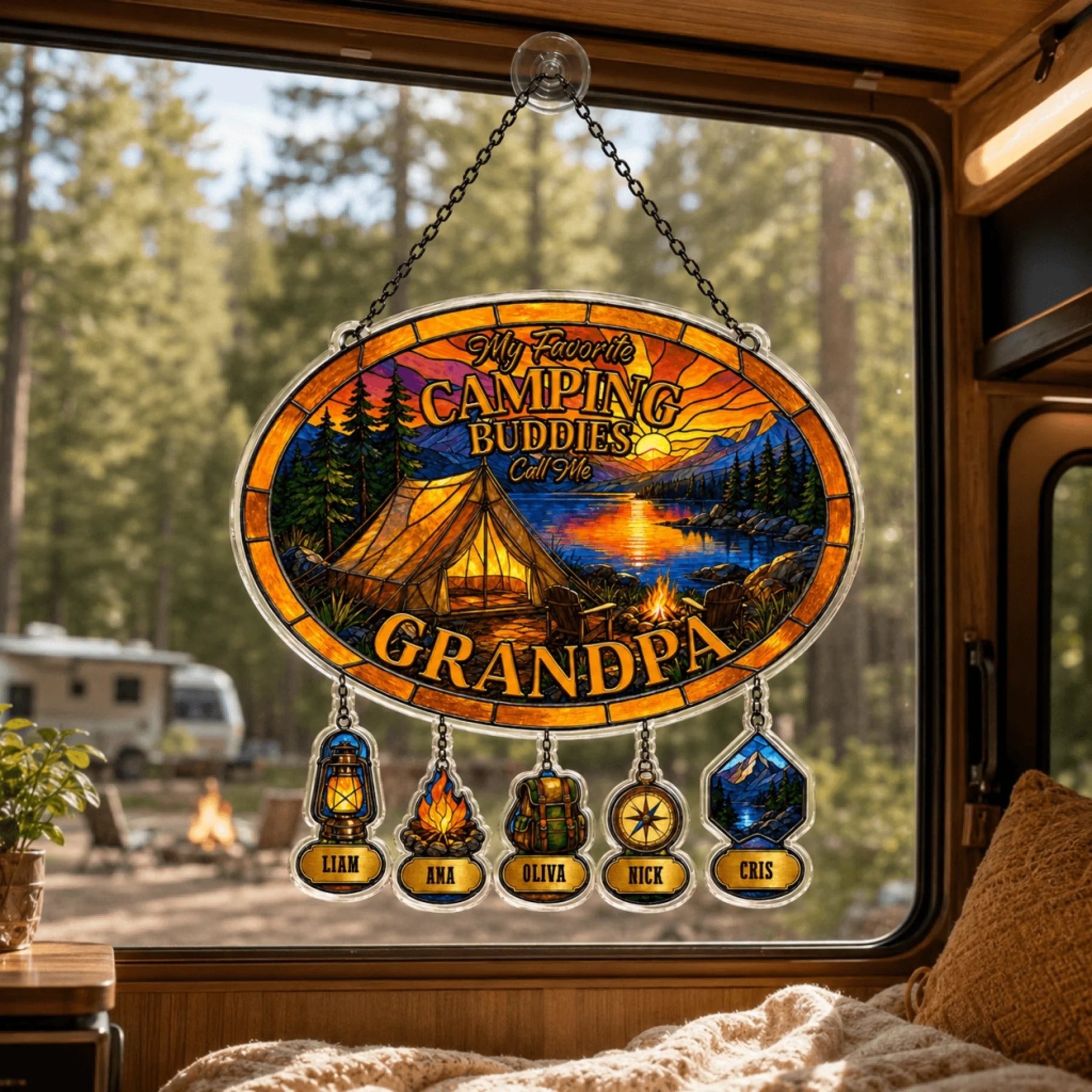 Decorative sign with camping theme hanging inside a vehicle, showing a scenic view of a lake and trees.