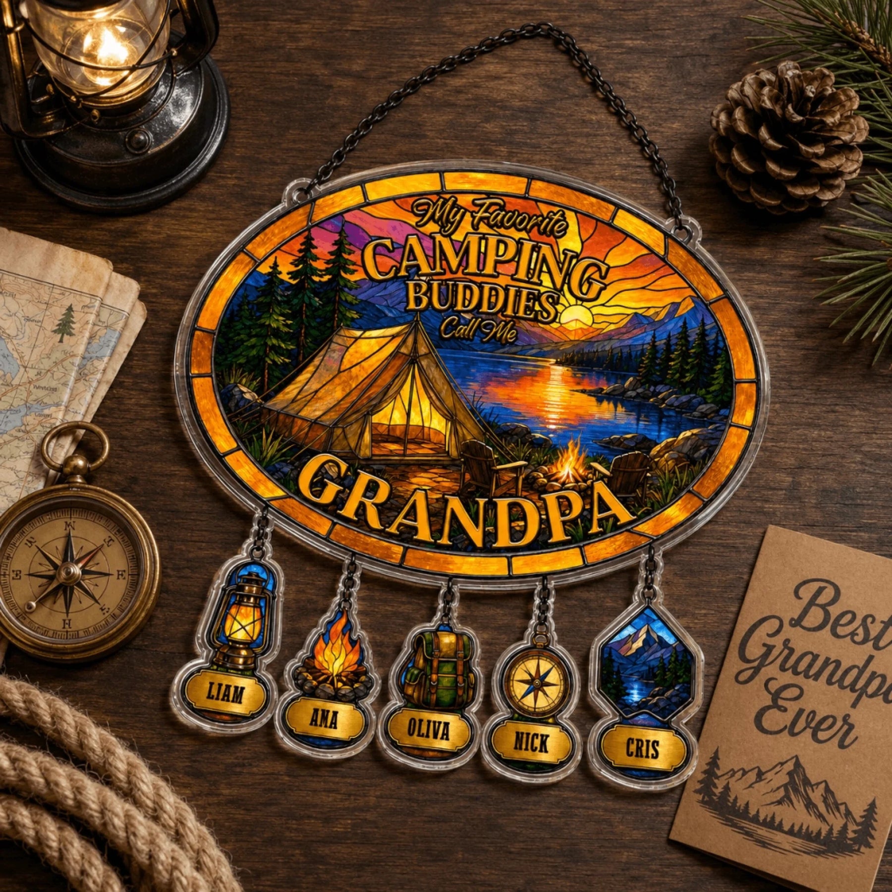Decorative sign with camping theme and names on a wooden surface with lantern and map.