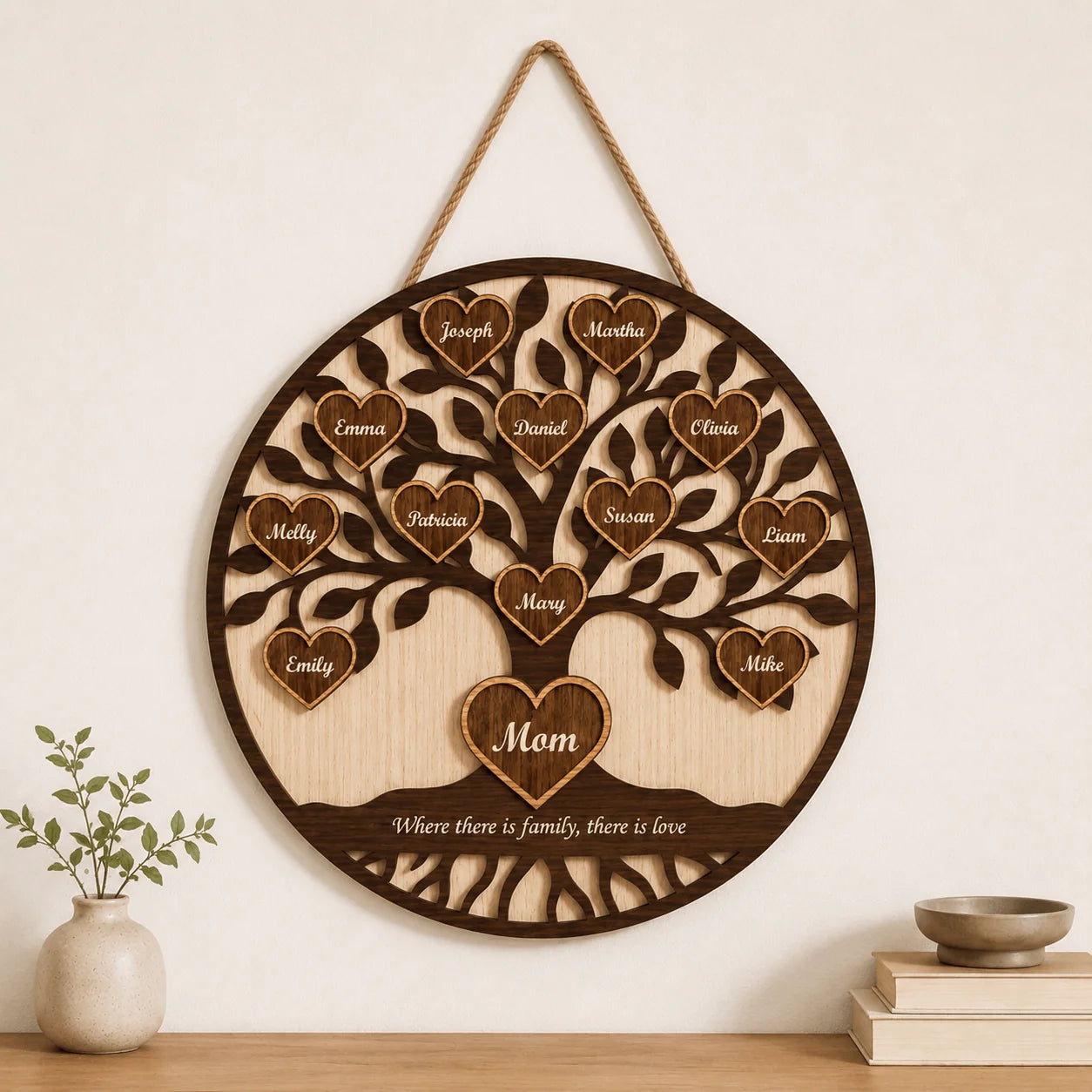 Wooden family tree wall hanging with engraved names and 'Mom' at the center, on a neutral background.